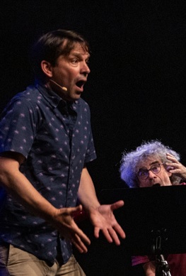 Schauspieler Juri Tetzlaff in lebhafter Pose mit Musiker im Hintergrund während des Familienkonzerts Die kleine Meerjungfrau in der Kulturhalle Süßen. Foto: Staufenpress.