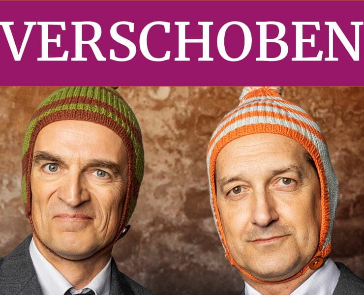 Ulan & Bator mit ihren charakteristischen Wollmützen. Ein violetter Banner mit der Aufschrift „VERSCHOBEN“ weist auf die Verschiebung der Veranstaltung „Überraschungszwei“ in der Kulturhalle Süßen hin.