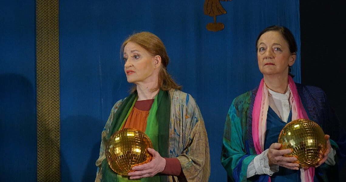 Zwei Frauen auf einer Bühne halten goldene Kugeln in den Händen. Nachmittagstheater: Es wird ein Engel dir gesandt