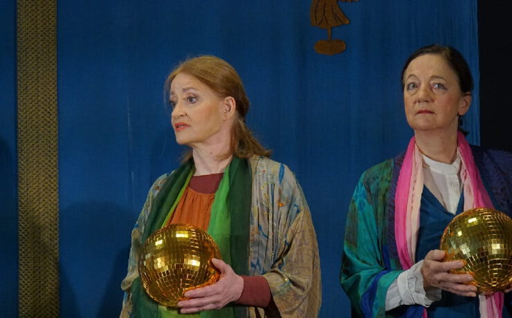 Zwei Frauen auf einer Bühne halten goldene Kugeln in den Händen. Nachmittagstheater: Es wird ein Engel dir gesandt
